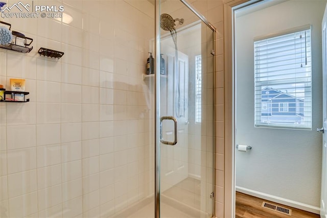 full bathroom featuring wood finished floors, a shower stall, visible vents, and baseboards