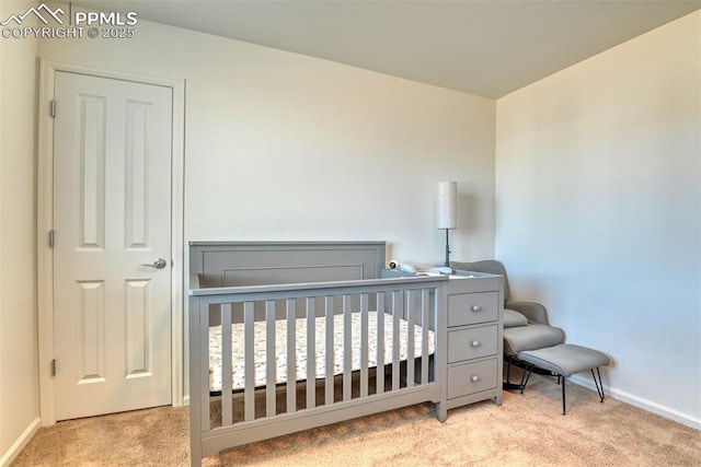 bedroom featuring a nursery area, carpet floors, and baseboards