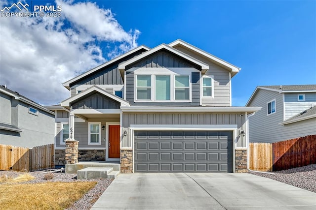 craftsman-style house with driveway, stone siding, an attached garage, fence, and board and batten siding