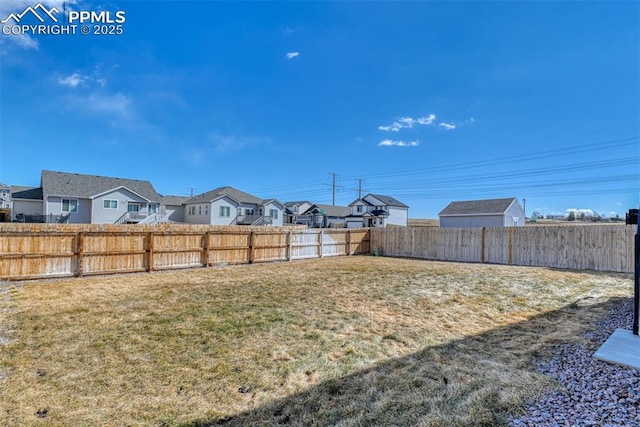 view of yard featuring a fenced backyard and a residential view