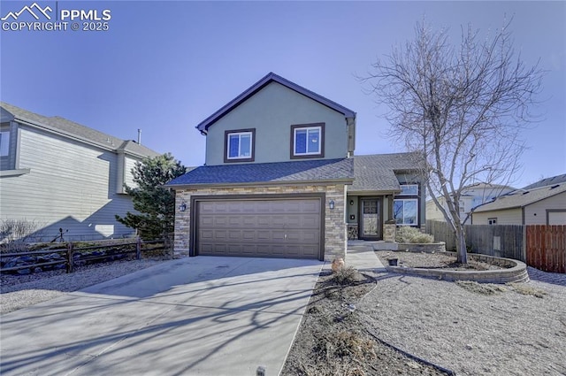 traditional-style home with a garage, stone siding, fence, and concrete driveway