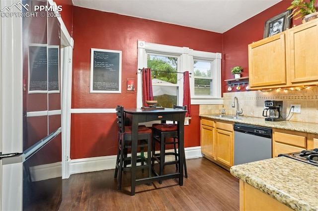 kitchen with baseboards, dark wood finished floors, a sink, stainless steel dishwasher, and tasteful backsplash
