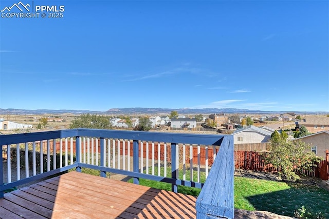 wooden deck featuring a mountain view, fence, and a residential view