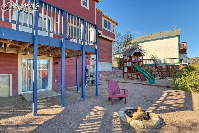 view of jungle gym with an outdoor fire pit