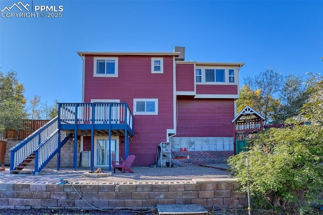 rear view of house with a deck, an outdoor fire pit, stairway, and fence