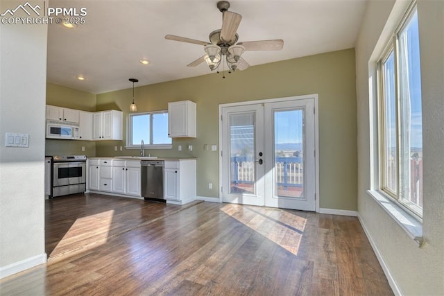 kitchen featuring stainless steel appliances, white cabinets, light countertops, french doors, and dark wood-style floors