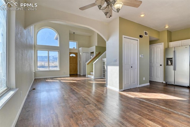 foyer entrance with a ceiling fan, visible vents, baseboards, and hardwood / wood-style floors