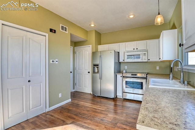 kitchen with stainless steel appliances, light countertops, visible vents, white cabinets, and a sink