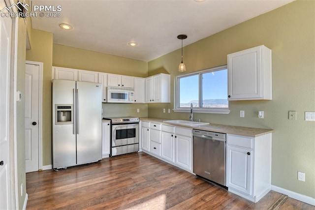 kitchen featuring appliances with stainless steel finishes, white cabinetry, and a sink