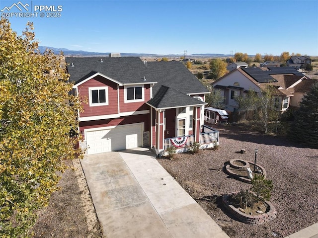 view of front facade featuring an attached garage, a porch, concrete driveway, and roof with shingles