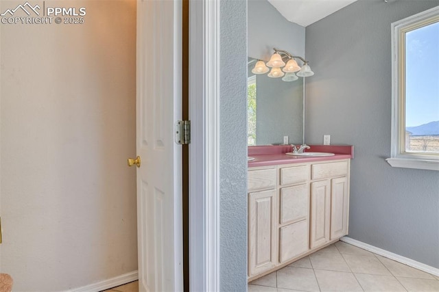 bathroom featuring double vanity, tile patterned floors, a sink, and baseboards