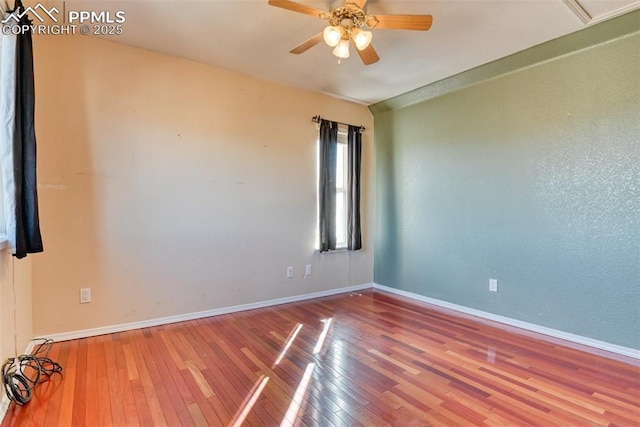 spare room featuring a ceiling fan, baseboards, and hardwood / wood-style floors