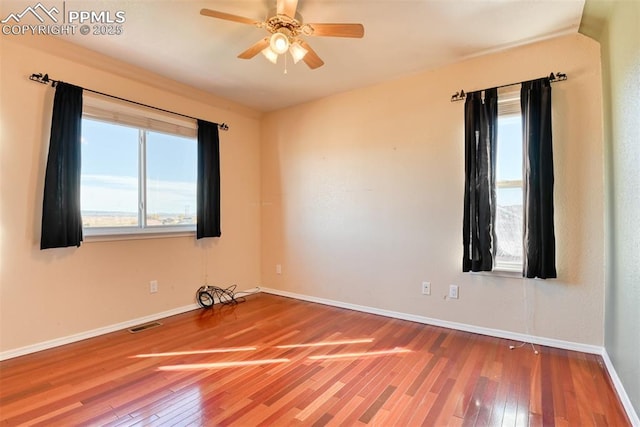 empty room with visible vents, baseboards, and hardwood / wood-style floors