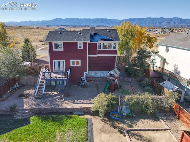 back of house with stairs, fence, a mountain view, and a patio