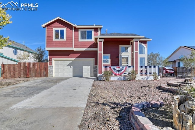 view of front of home with concrete driveway, covered porch, fence, and an attached garage