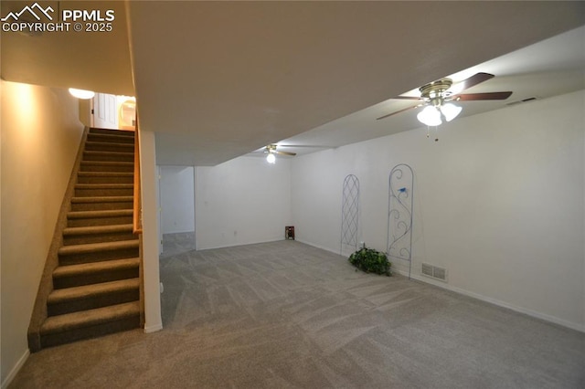 finished basement featuring stairs, carpet floors, visible vents, and a ceiling fan