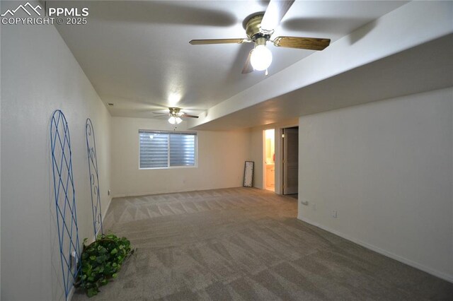 carpeted empty room featuring baseboards and a ceiling fan