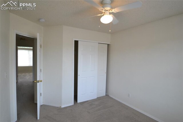 unfurnished bedroom with a textured ceiling, carpet floors, and a closet