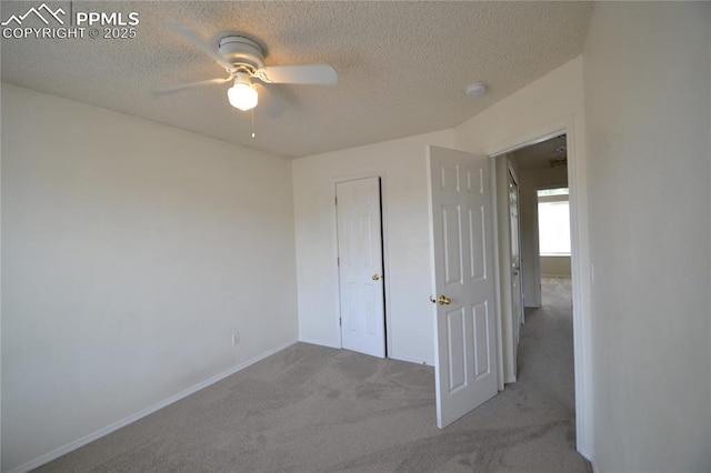 unfurnished bedroom featuring a textured ceiling, carpet flooring, a ceiling fan, and baseboards