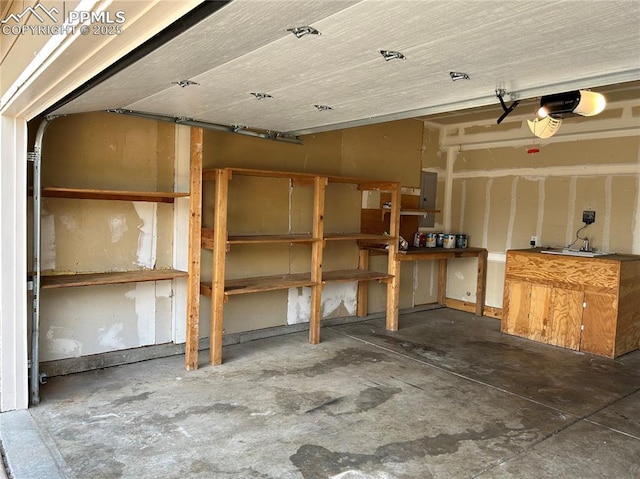 garage featuring electric panel and a garage door opener