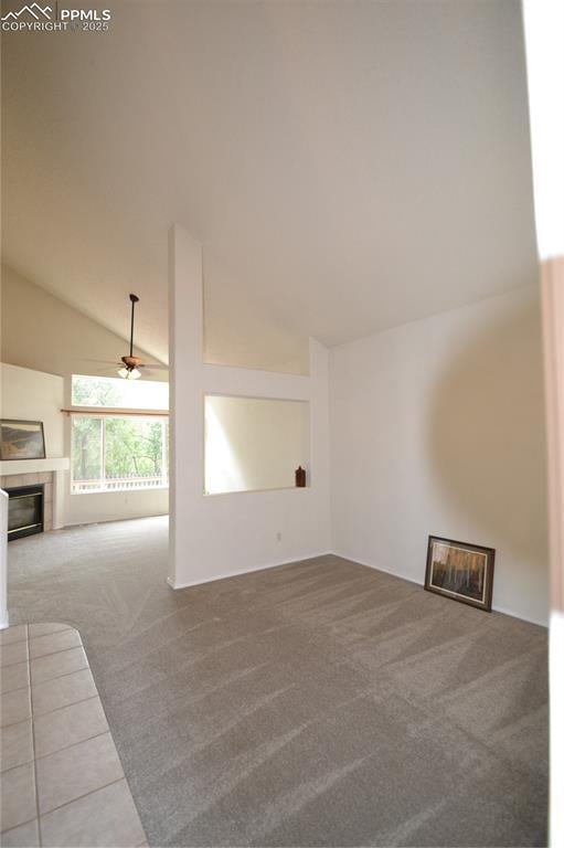 unfurnished living room with high vaulted ceiling, carpet, a fireplace, and ceiling fan