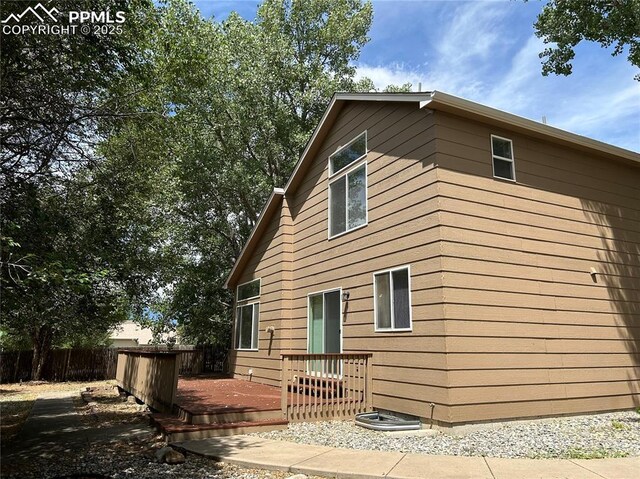 back of house with fence and a deck