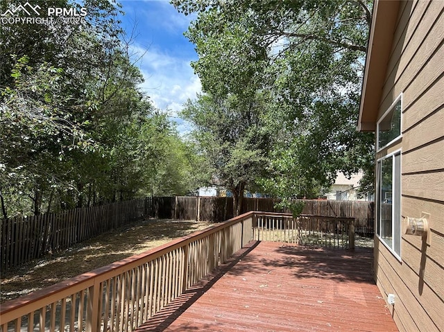 wooden terrace with a fenced backyard