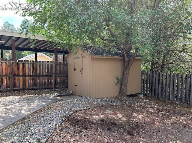 exterior space with a shed, a fenced backyard, and an outdoor structure