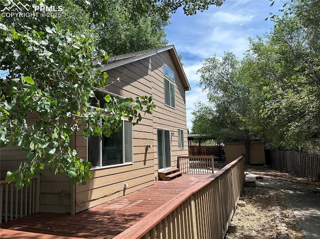 815 Riverview Ln, Colorado Springs, CO 80916 - wooden deck featuring an outbuilding, a storage unit, and fence