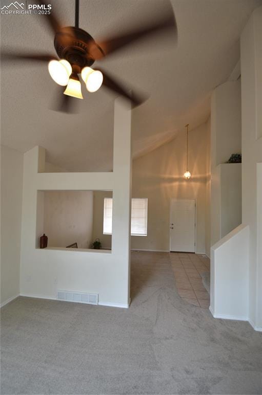 interior space featuring lofted ceiling, ceiling fan, carpet flooring, and visible vents