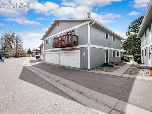 view of property exterior with a garage and a balcony