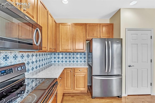 kitchen with light wood-style floors, appliances with stainless steel finishes, decorative backsplash, and recessed lighting