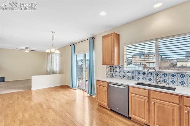 kitchen featuring light wood-style flooring, a sink, light countertops, stainless steel dishwasher, and tasteful backsplash