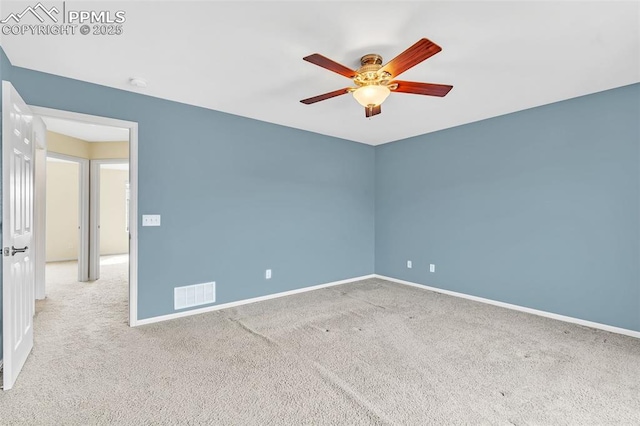 carpeted empty room featuring baseboards, visible vents, and a ceiling fan