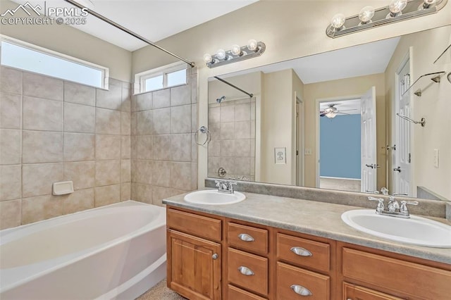 bathroom featuring double vanity, tub / shower combination, and a sink