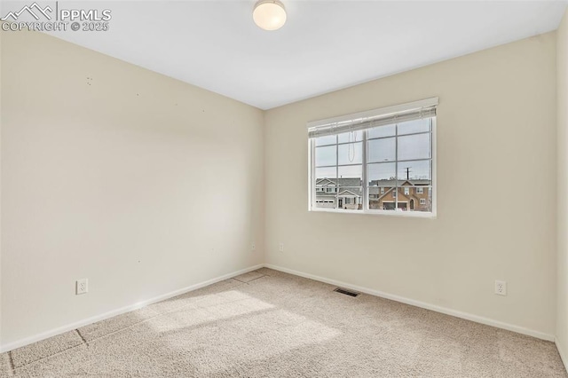 carpeted empty room featuring visible vents and baseboards