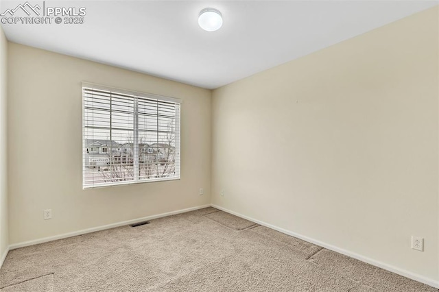 carpeted spare room with visible vents and baseboards