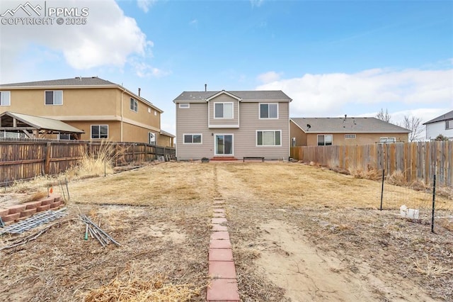 back of house with a fenced backyard and a yard