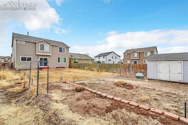 view of yard with an outbuilding, fence, a residential view, and a storage shed