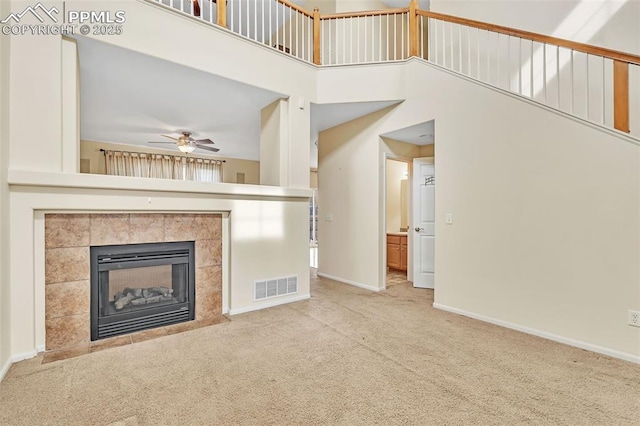 unfurnished living room featuring carpet, visible vents, a fireplace, and baseboards