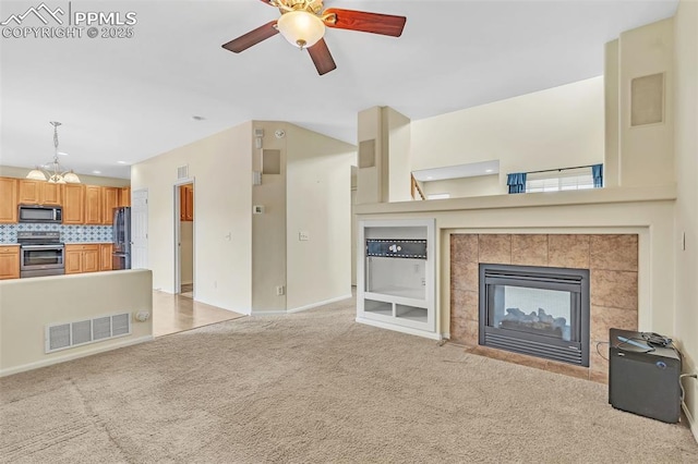 unfurnished living room featuring ceiling fan, light colored carpet, visible vents, baseboards, and a tiled fireplace