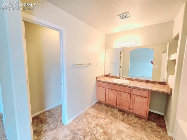 bathroom with vanity, baseboards, and visible vents