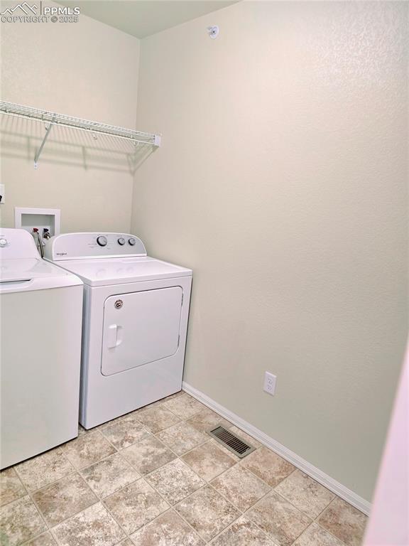 laundry area with independent washer and dryer, laundry area, baseboards, and visible vents