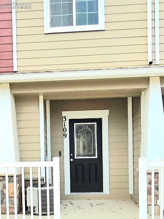 entrance to property featuring central air condition unit and covered porch