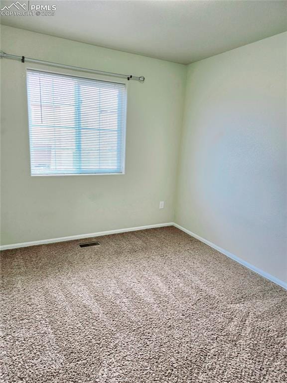 carpeted empty room with visible vents and baseboards