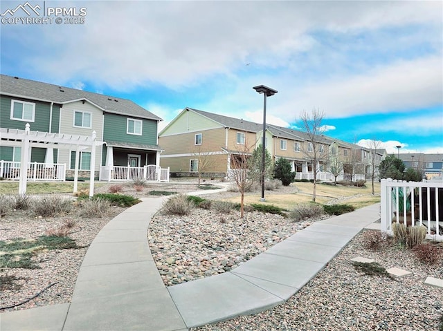 view of community with a residential view and a pergola