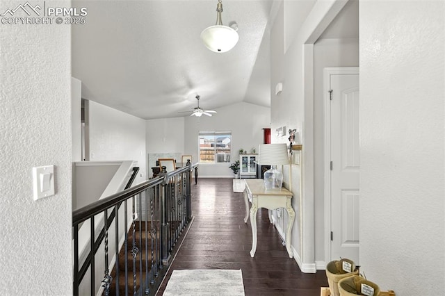 corridor featuring vaulted ceiling, an upstairs landing, wood finished floors, and baseboards