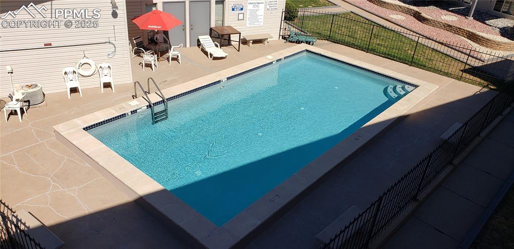 pool with fence and a patio