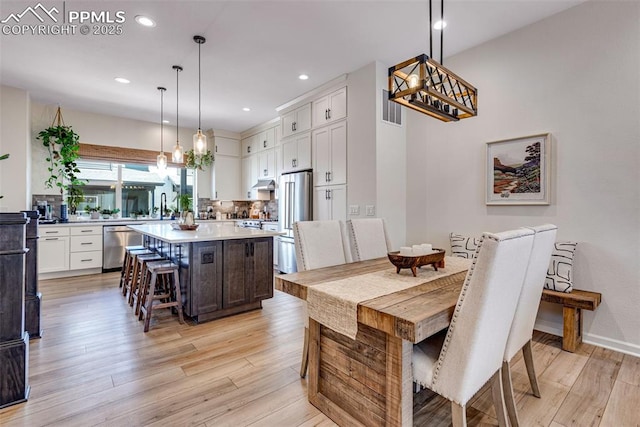 dining space featuring recessed lighting, visible vents, light wood-style flooring, and baseboards