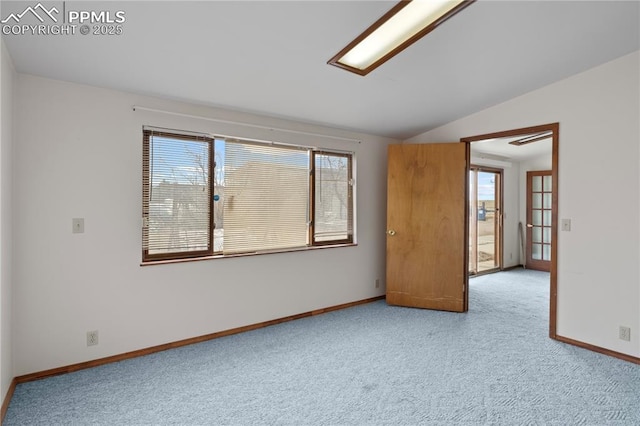 unfurnished room with vaulted ceiling, carpet flooring, a wealth of natural light, and baseboards